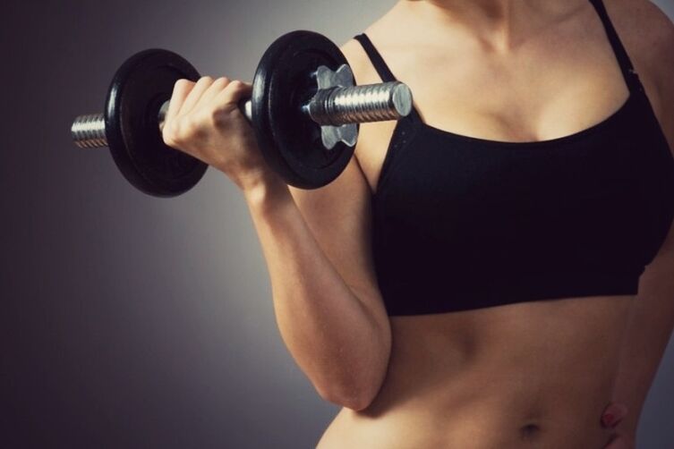 Gumagawa ng mga ehersisyo gamit ang mga dumbbells upang palakihin ang iyong mga suso